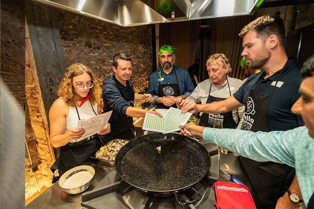 Chef cooking, cutting some shrimp to prepare a rice dish or paella in Barcelona.