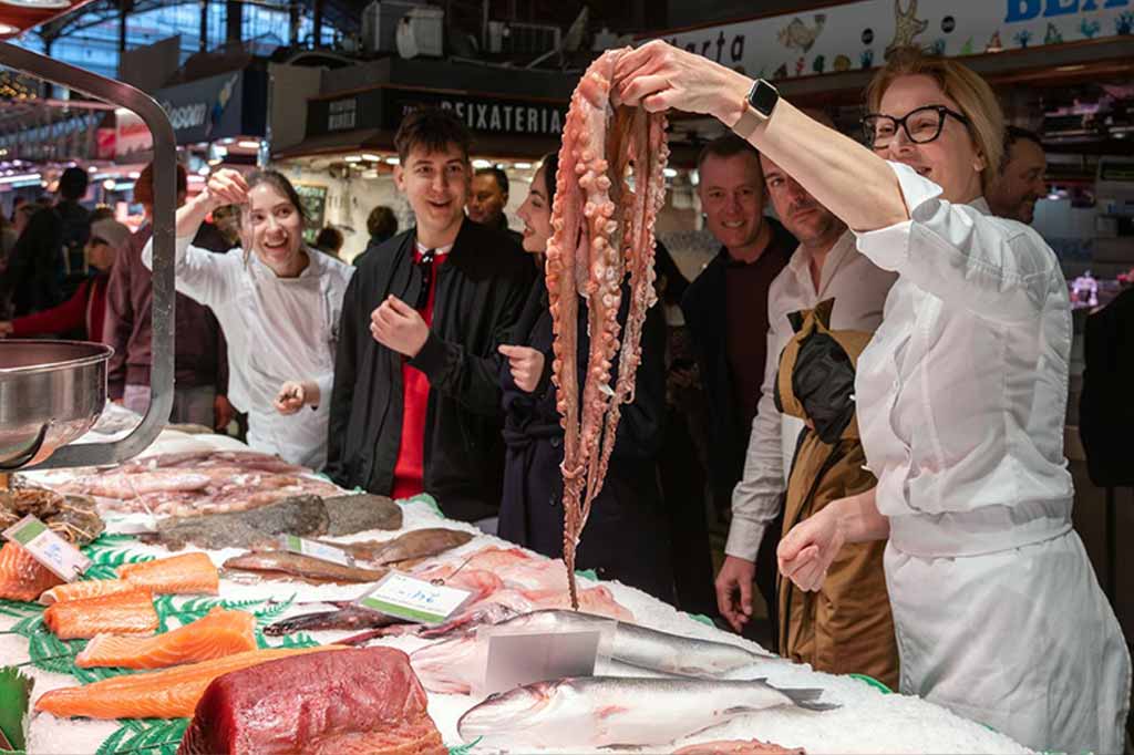 Group choosing fresh ingredients at the Boqueria Market before the paella class.
