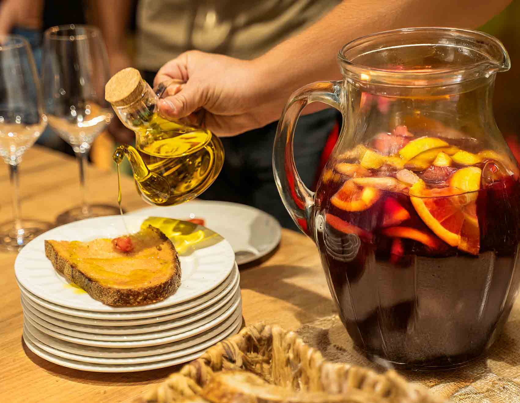 Photo of the sangria and tomato bread activity within the team building workshop in Barcelona: the chef explains the secrets of authentic Spanish sangria and the participants prepare their own sangria with fruit and local wine before the paella experience.