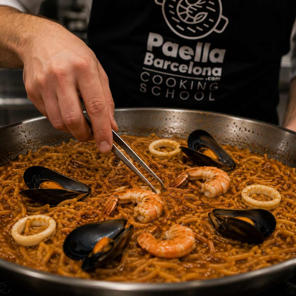 Foto de un taller de paella para empresas en Barcelona donde el equipo cocina junto y colabora en pasos interconectados. Actividad de team building culinario con responsabilidades definidas, participación de todos y enfoque en cohesión, comunicación y éxito colectivo.