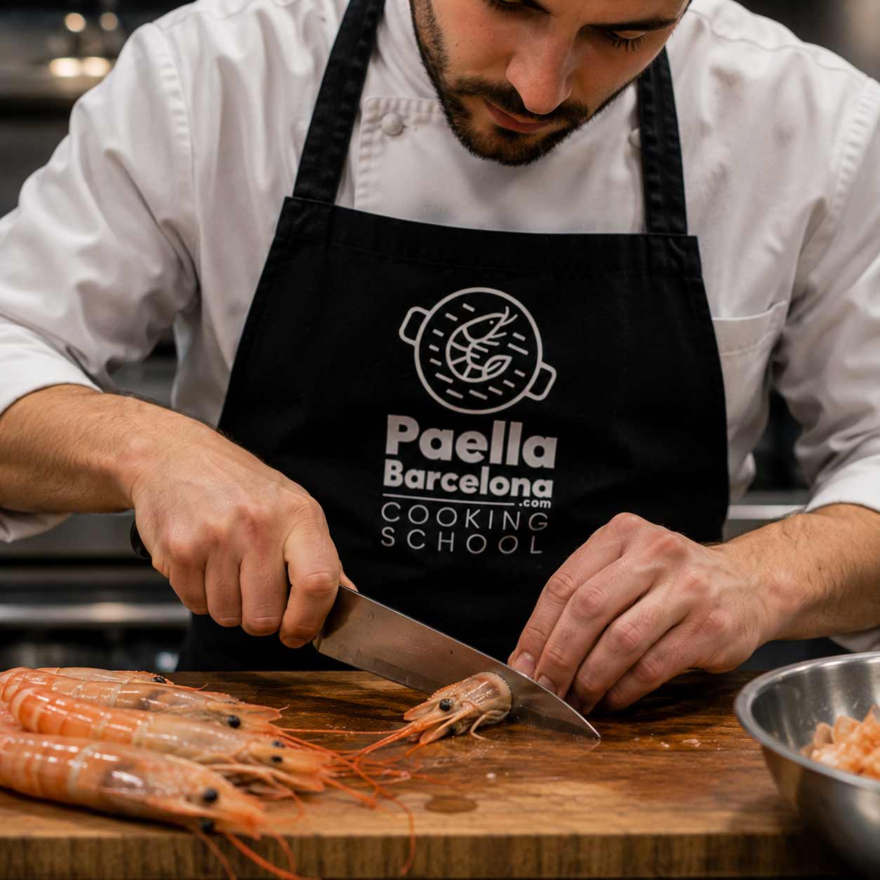 Foto de un taller de paella para empresas en Barcelona donde el equipo cocina junto y colabora en pasos interconectados. Actividad de team building culinario con responsabilidades definidas, participación de todos y enfoque en cohesión, comunicación y éxito colectivo.